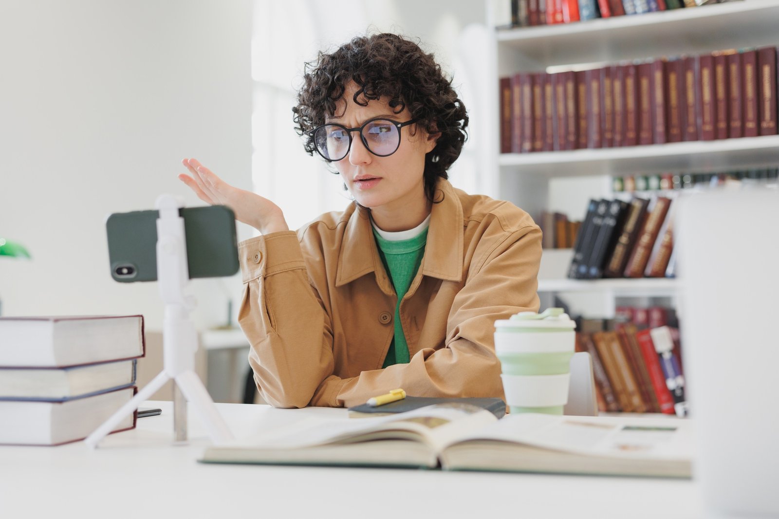 woman watches webinar from phone in office, coworking or library. work and study online